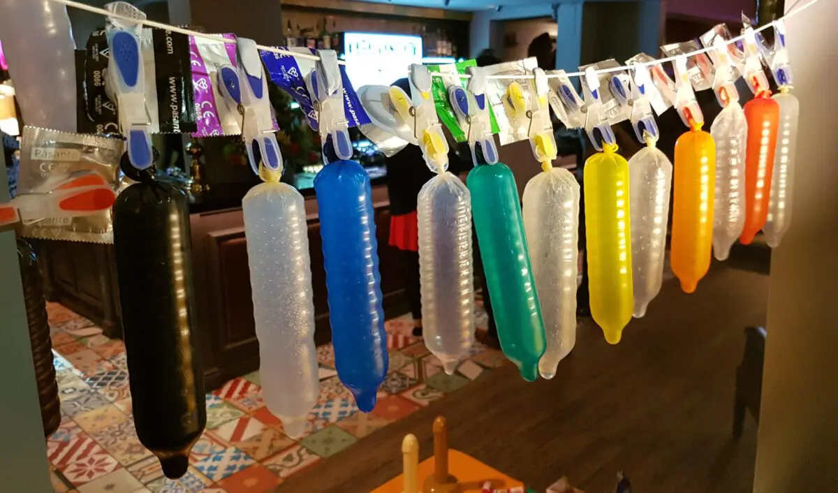 Colourful range of condoms inflated to size and hung on a line.