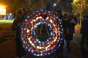 Wreath in the trans flag colours (pink, white, and blue), lit up with fairy lights and carried by volunteers at Trans Day of Remembrance walk, 20 November 2025